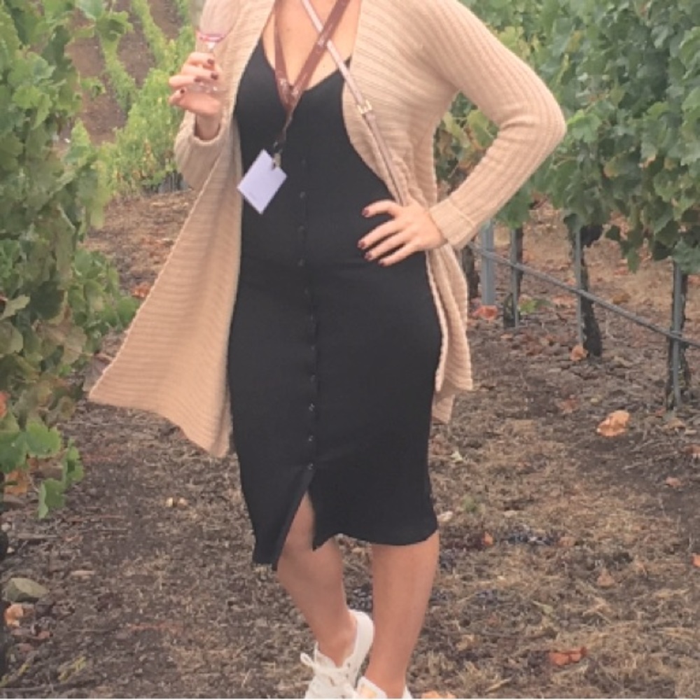 Black, ribbed, form fitting, sleeveless black button down dress.  Versatile.